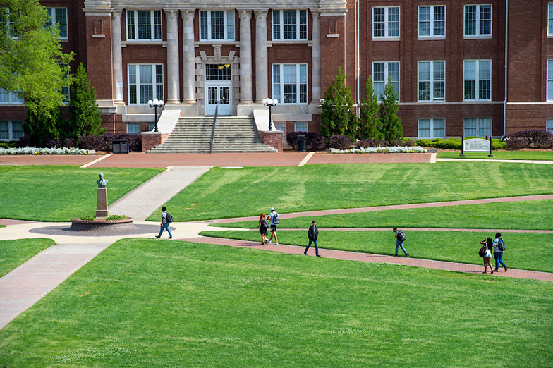 Aerial shot of students walking on the Drill Field with Lee Hall in the background.