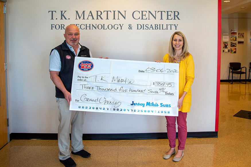 Jersey Mike's owner Bret Dunnaway and center director Kasee Stratton-Gadke holding a donation check.