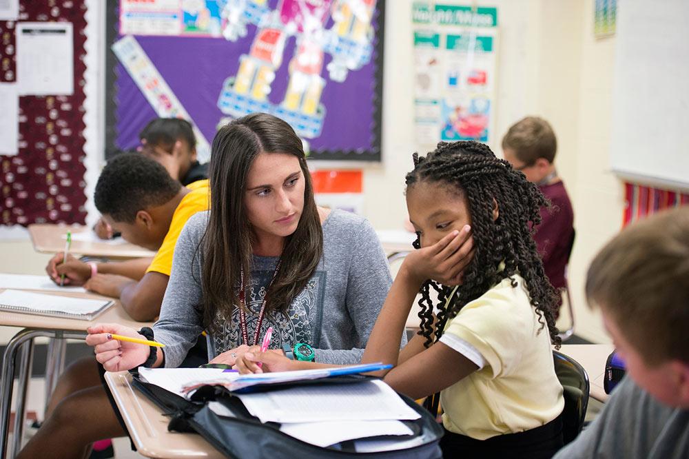 Teacher with student in classroom.