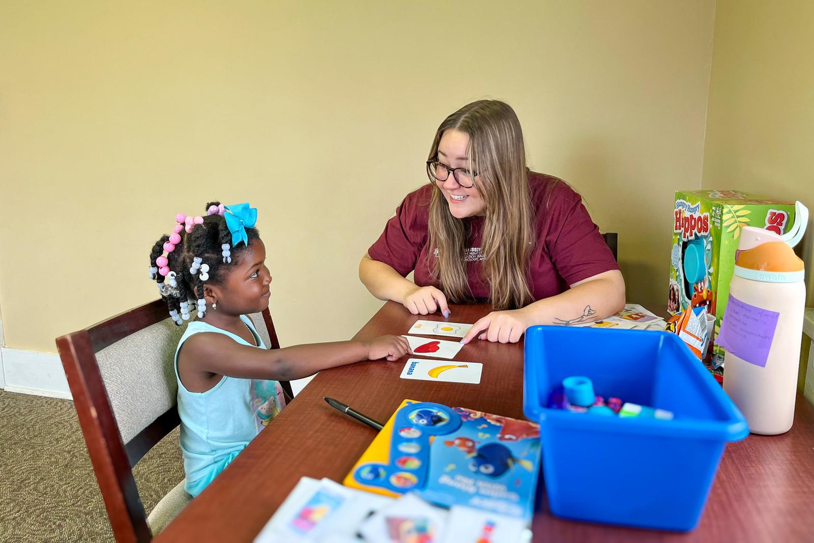 MSU student works with a child at a table