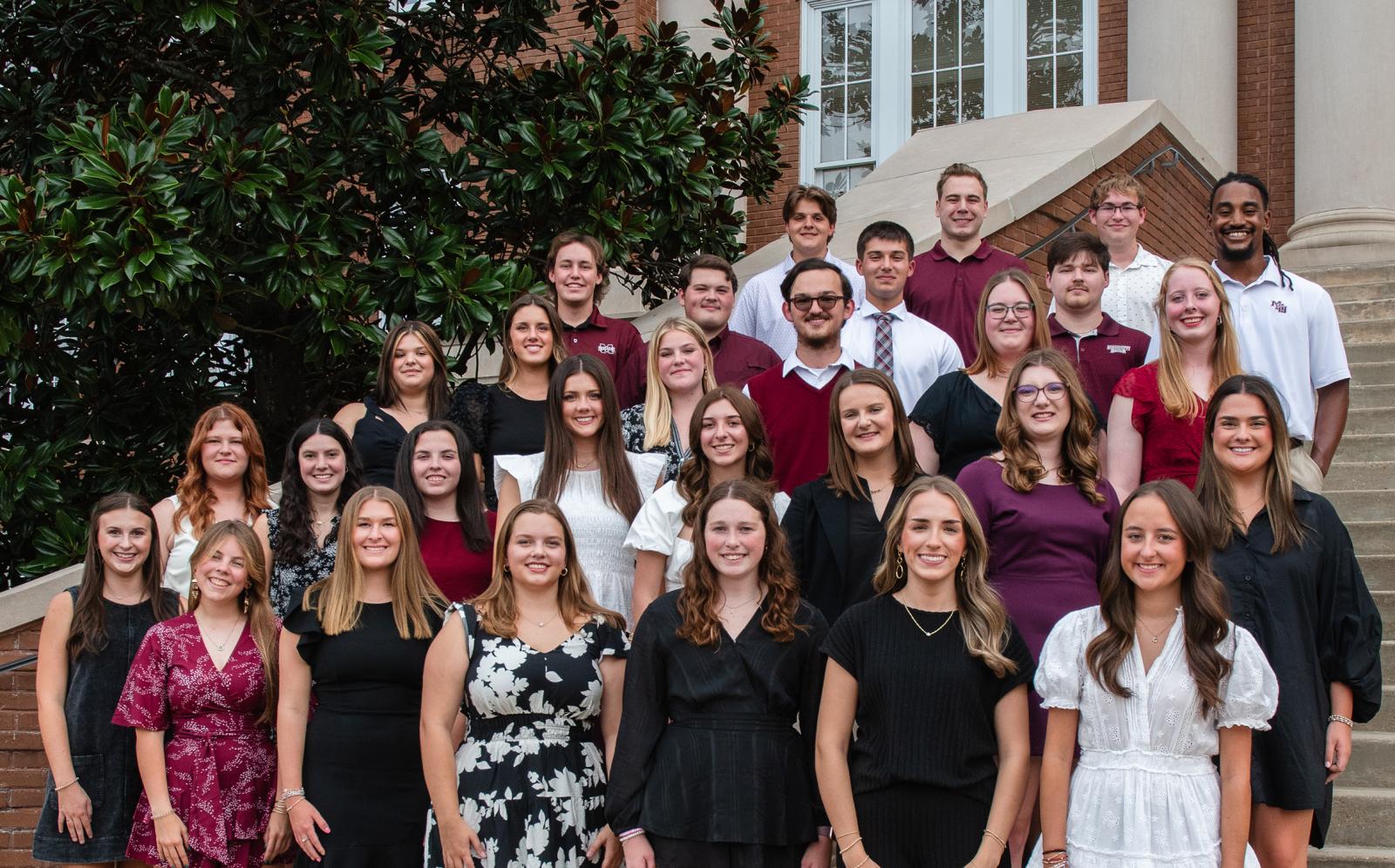 METP cohort poses on steps for a group photo
