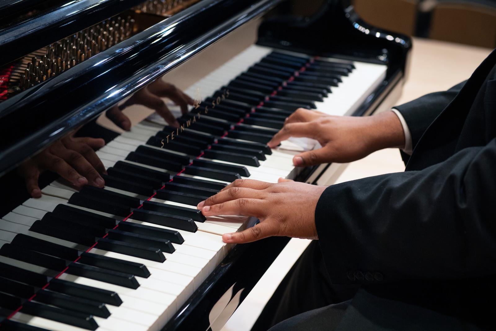 Hands of a student playing the piano