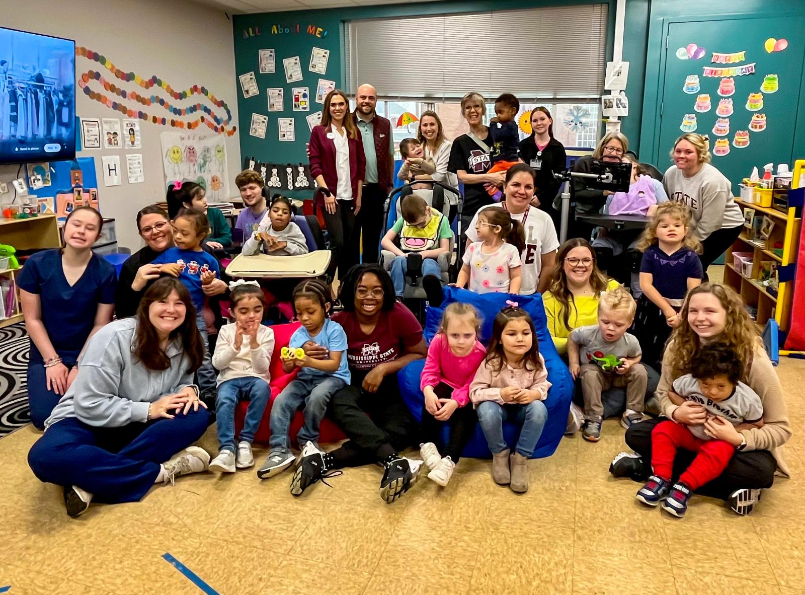 Children and T.K. Martin staff pose for a photo in a classroom.