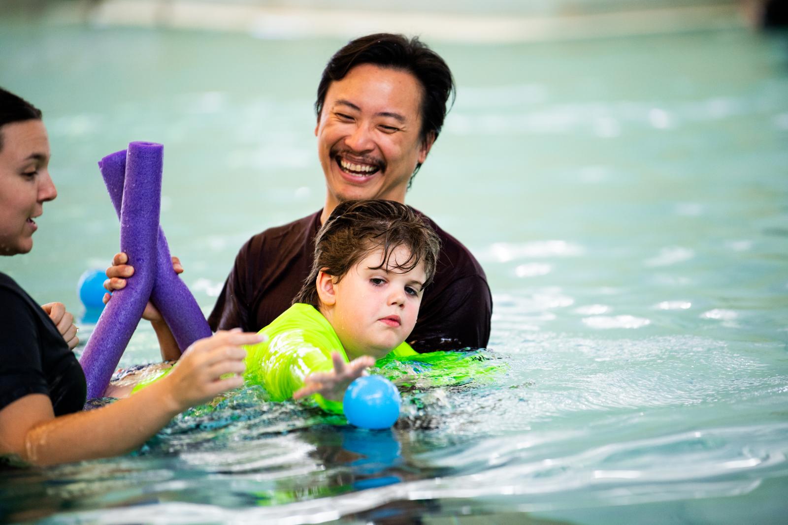 MSU student helping a child learn to swim in a pool