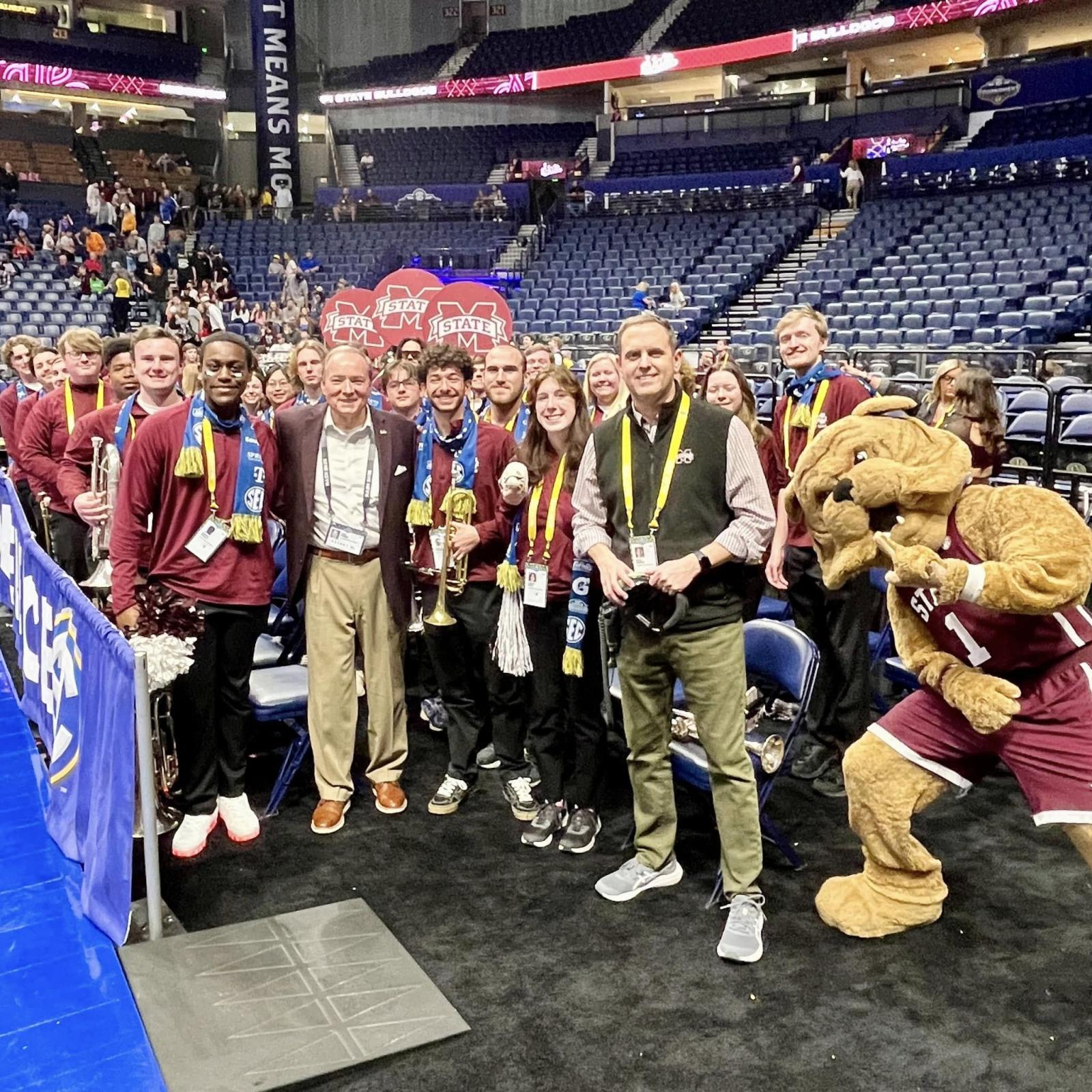 Band members, Bully and Dr. Aarhus pose for a photo with Dr. Keenum inside a basketball arena