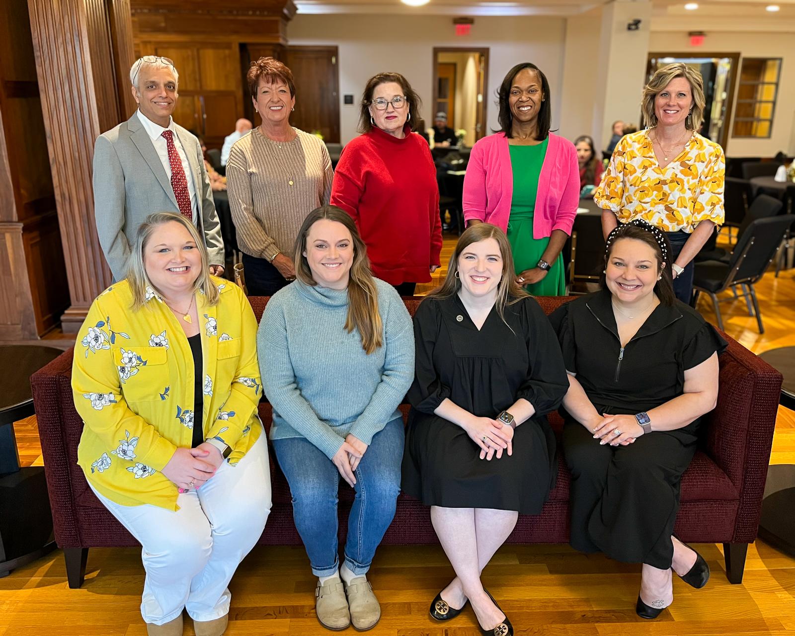 Nine teachers posed for a photo in the Grisham Room