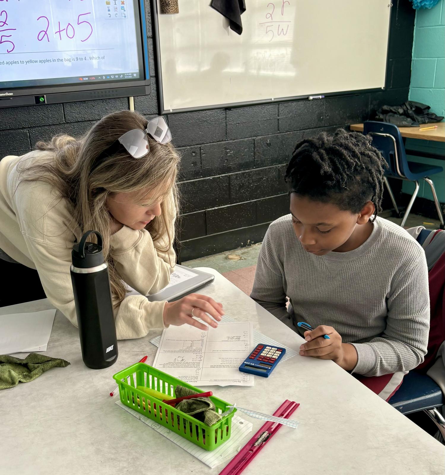 Teacher helps student in class