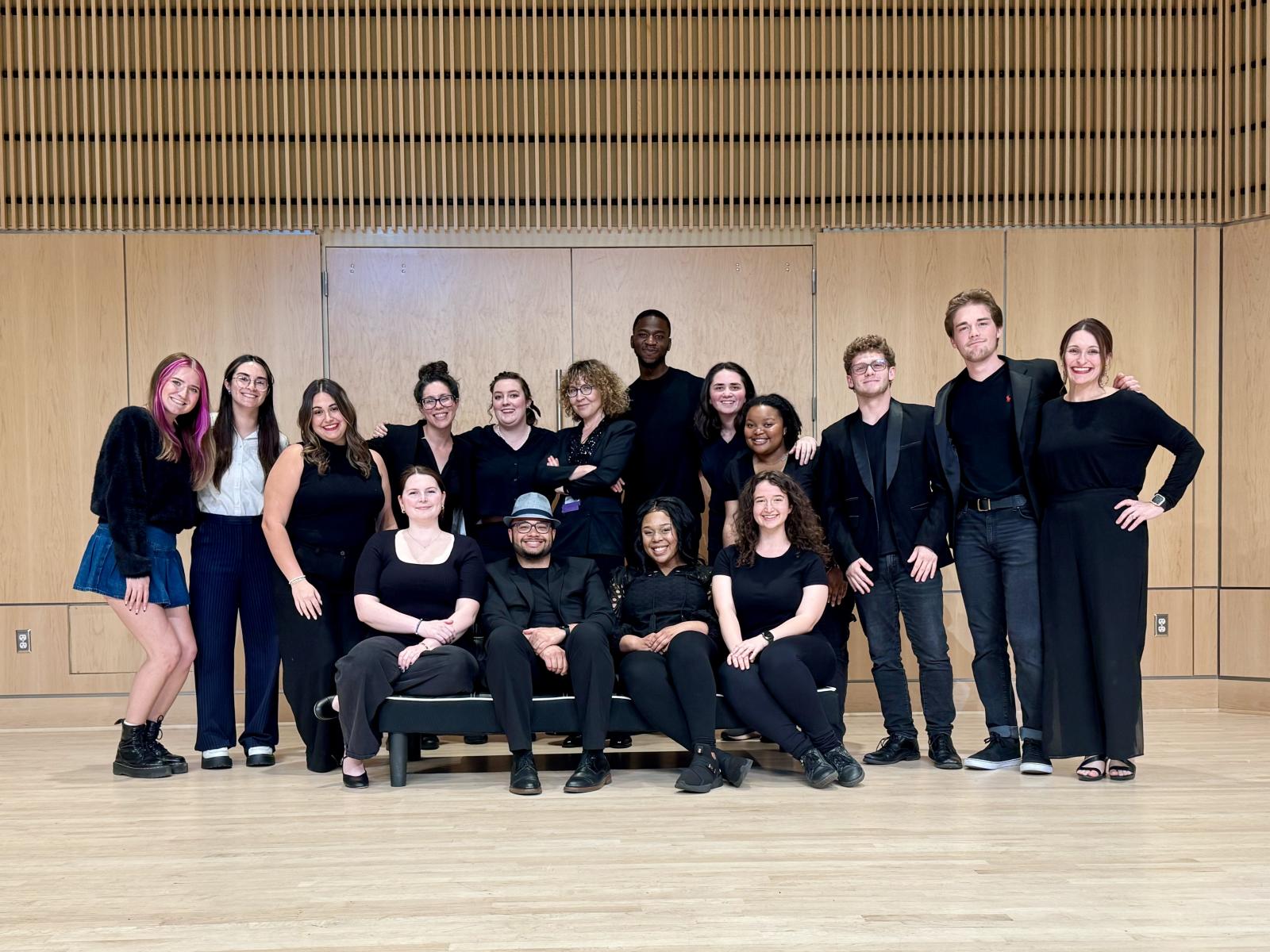 Opera performers gather onstage for a photo.