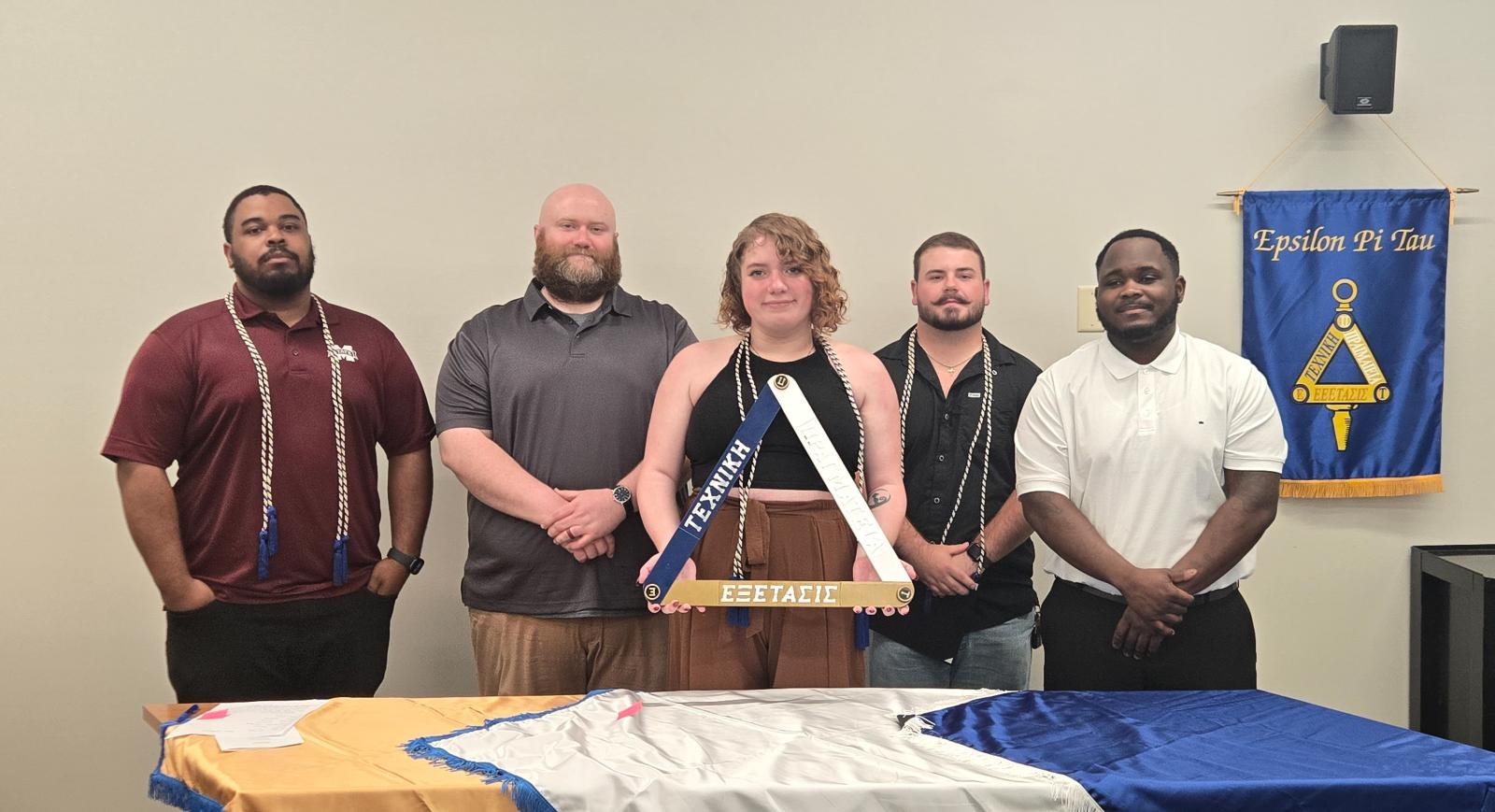 Five students pose for a photo during an honor society induction ceremony