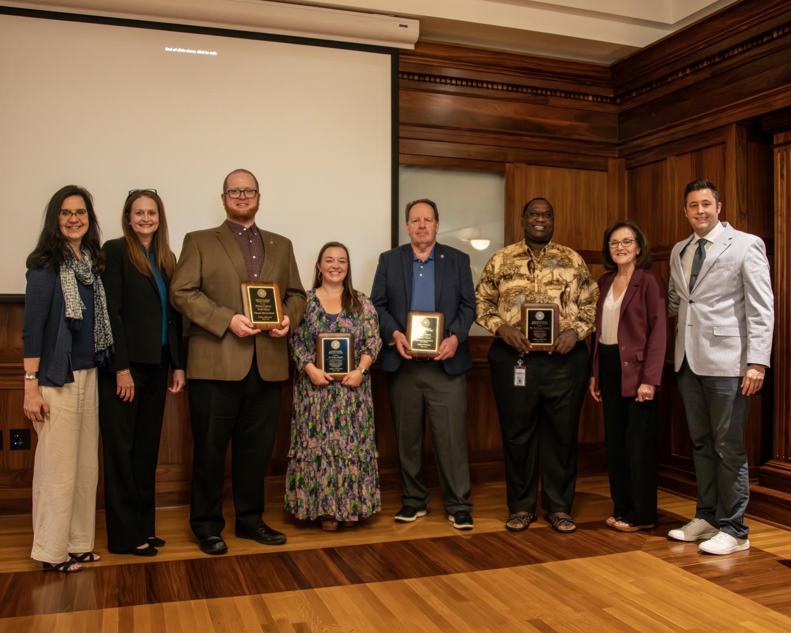 Faculty and staff award recipients pose for a photo with administration