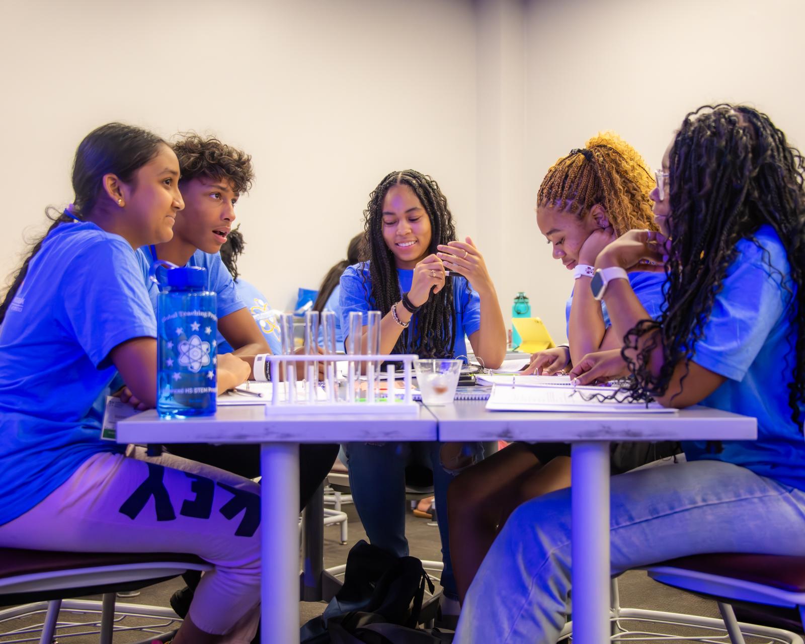 Five students gathered around table to work on STEM project