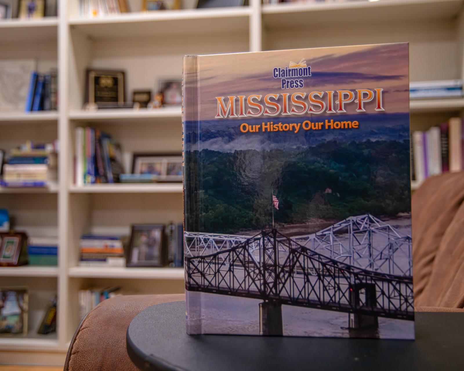Textbook sitting on a small table with book shelf in the background