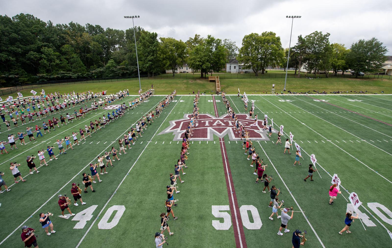 Students practice playing instruments on a band practice field