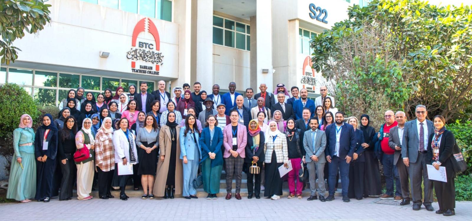A large group poses for a photo outside the Bahrain Teacher's College