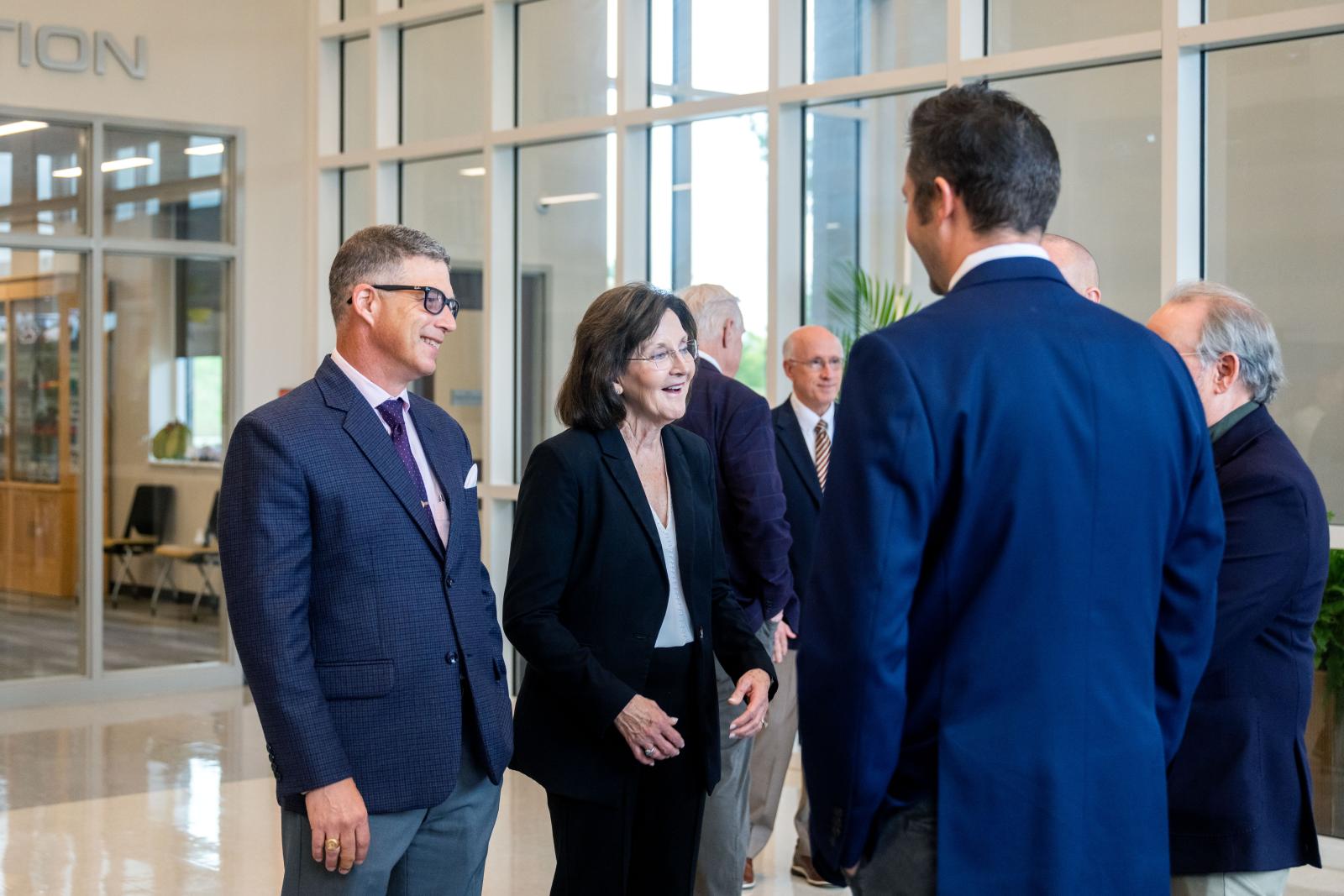 MSU leaders stand in school foyer talking