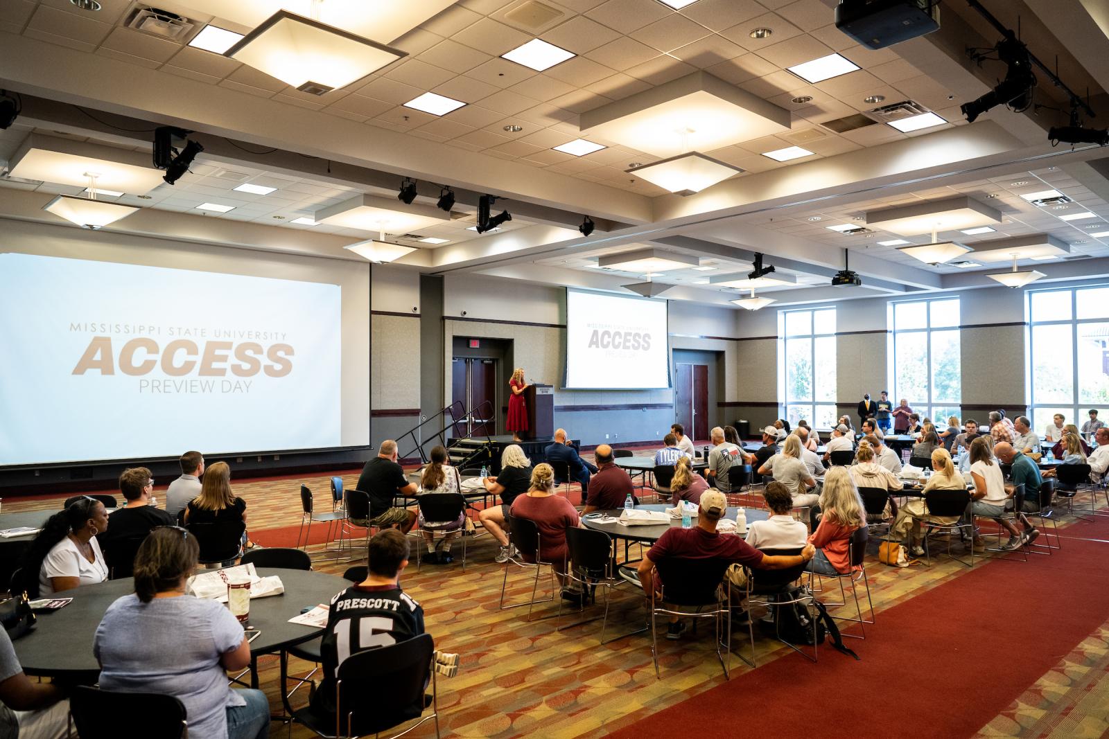 Prospective students and families seated around tables during a presentation in the Union ballroom