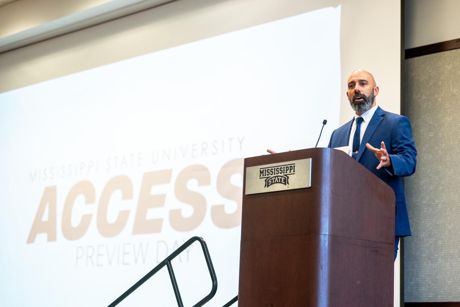 Jordan Spencer speaking at a podium during an event