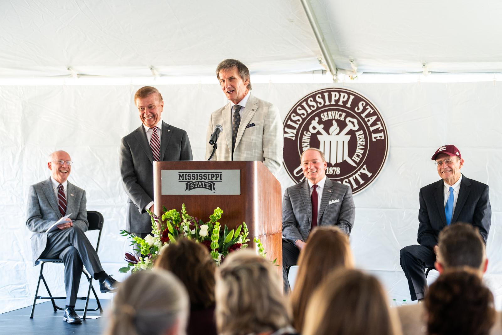 Duff brothers give speech during celebration under a tent