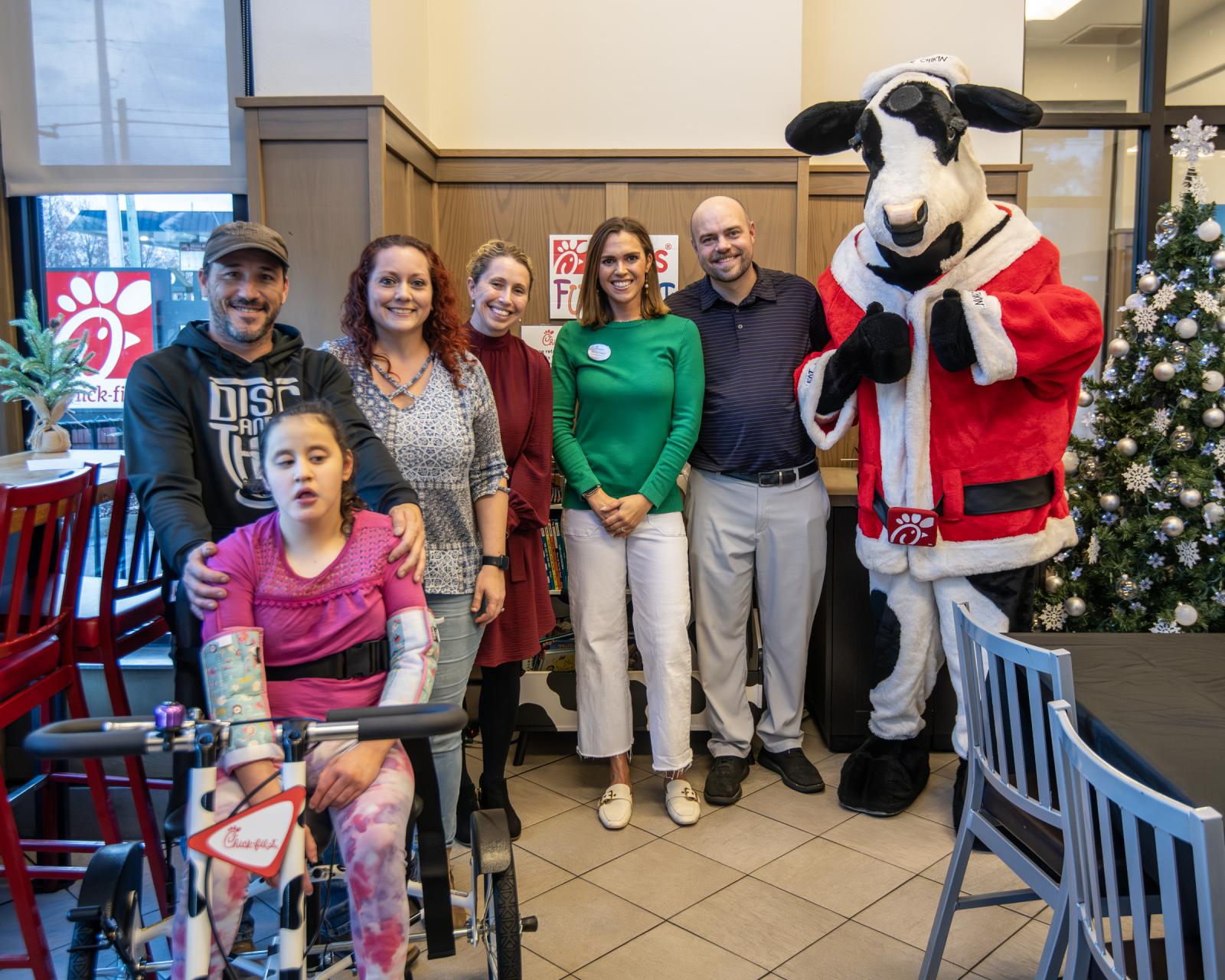 Pictured behind Alyssa, from left, are parents Jonathan and Brittany Greer, the university’s Mississippi Institute on Disabilities Executive Director Kasee Stratton-Gadke, local restaurant Community Connections Director Melissa Rogers, owner and operator Jonathan Rogers and mascot.