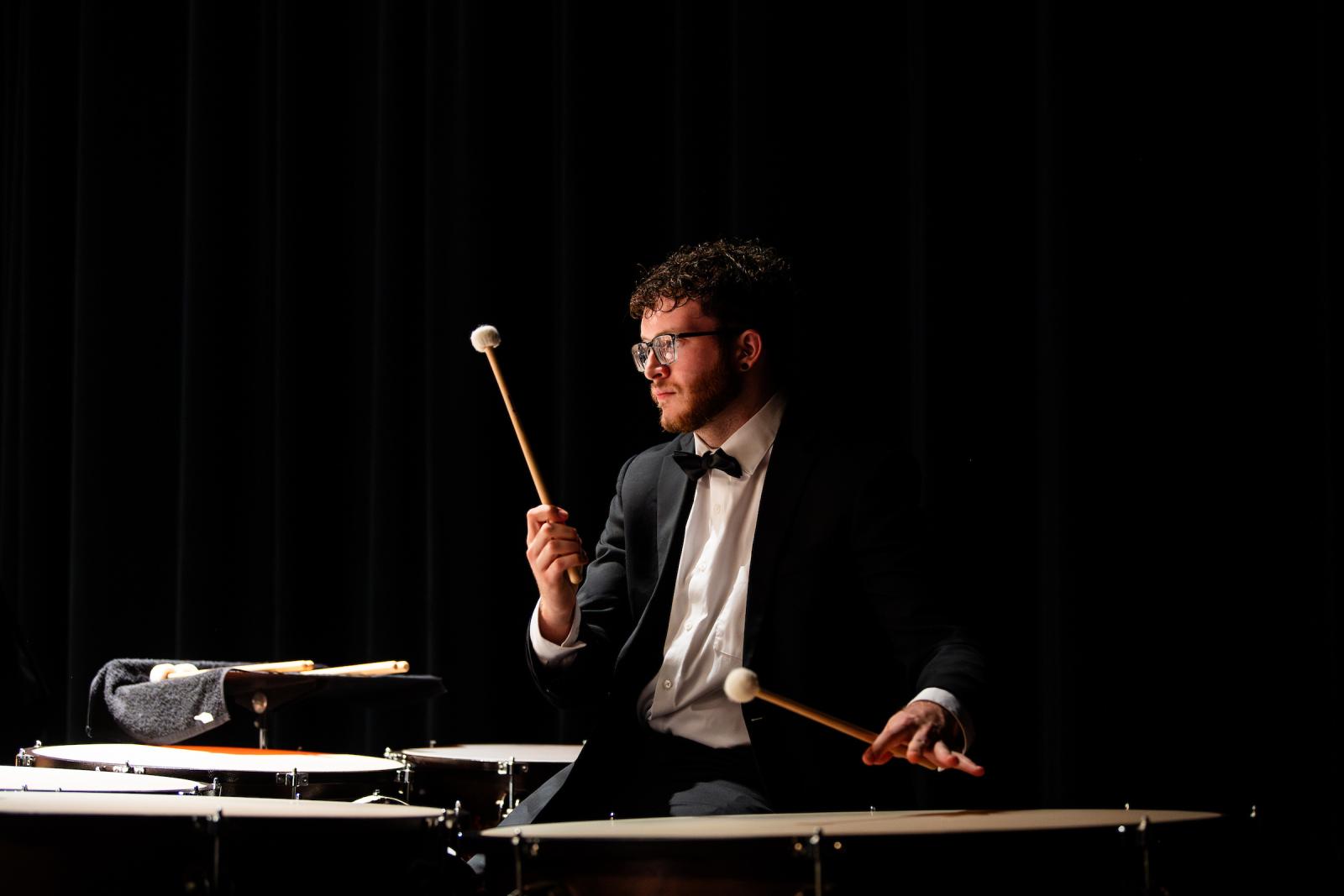 Student plays drums during a performance