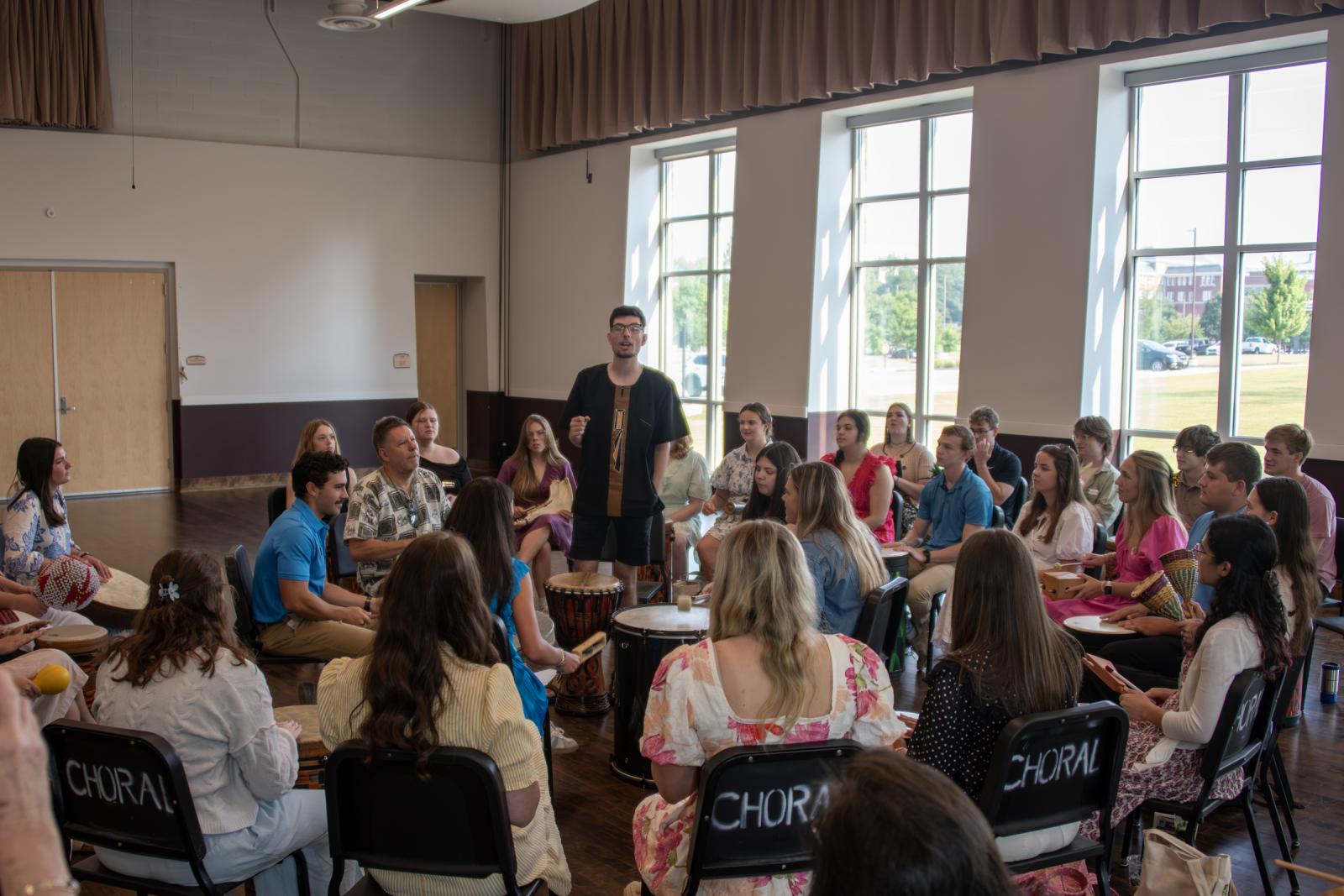 Dylan Hall leads METP students in song during a drum circle
