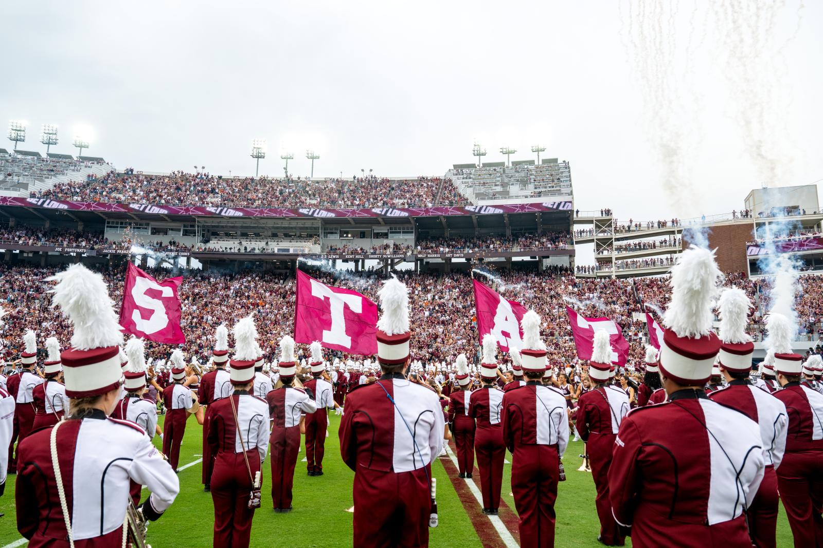 Famous Maroon Band members play instruments on football field