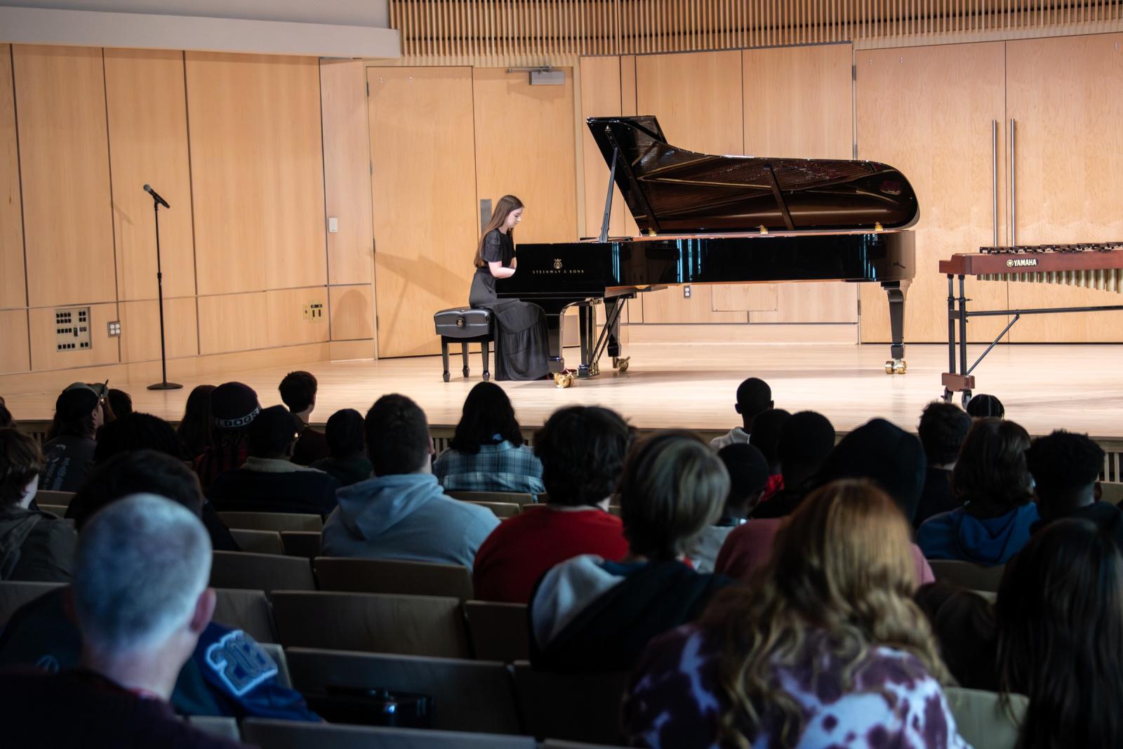 Pianist performs onstage in front of a large crowd