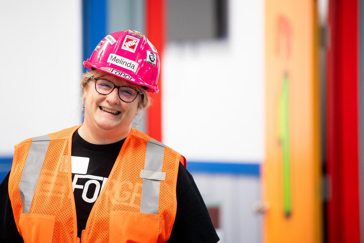Lady in hard hat and vest smiling