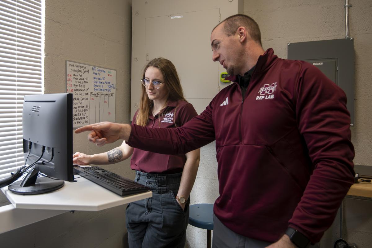 Gillen conducts research with student in a lab