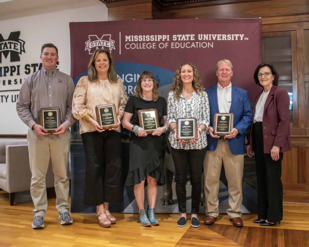 Five award winners pose for a photo with the dean