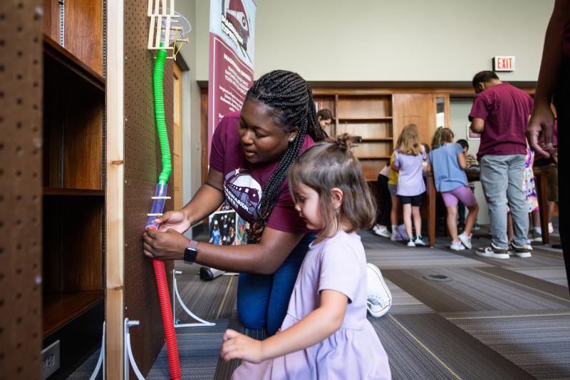 EPY student helps a child with an activity